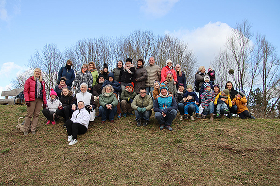 Die Teilnehmerinnen und Teilnehmer der Initiative "Von wegen Down" auf einer Wiese vor herbstlichen Bäumen.